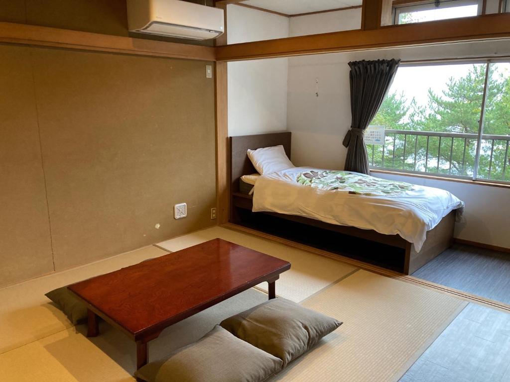大石Koya TRIBE - Vacation STAY 83089v的一间卧室配有一张床、一张桌子和一个窗户。