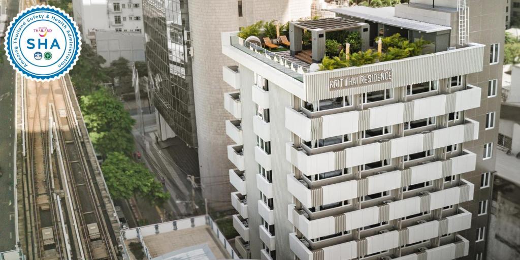 曼谷克利泰套房酒店的上面有植物的建筑