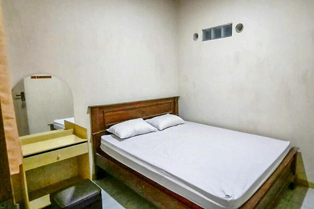 卡里蒙贾瓦Central House Karimunjawa RedPartner的一间小卧室,配有一张床和镜子