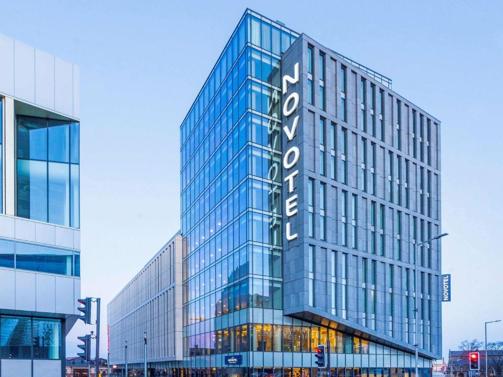 莱斯特Novotel Leicester的一座高大的玻璃建筑,上面有标志