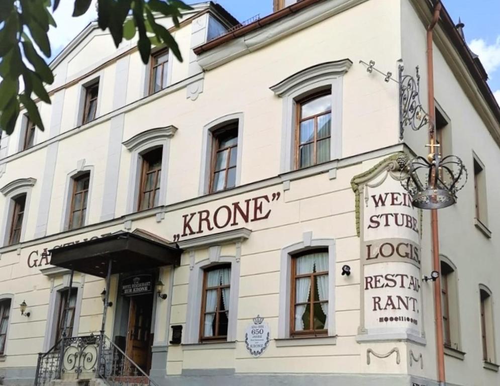 巴特布吕克瑙Hotel-Restaurant-Krone的白色的建筑,上面有标志