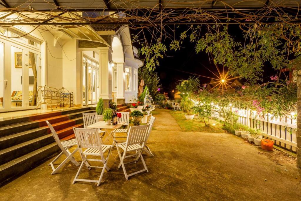 大叻Villa trung nghĩa 29的房屋前设有带桌椅的天井。