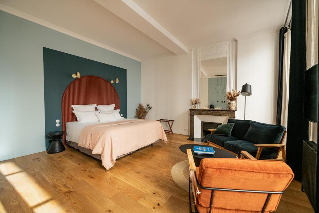波尔多Maison Fernand B&B的一间卧室配有一张床,客厅配有沙发