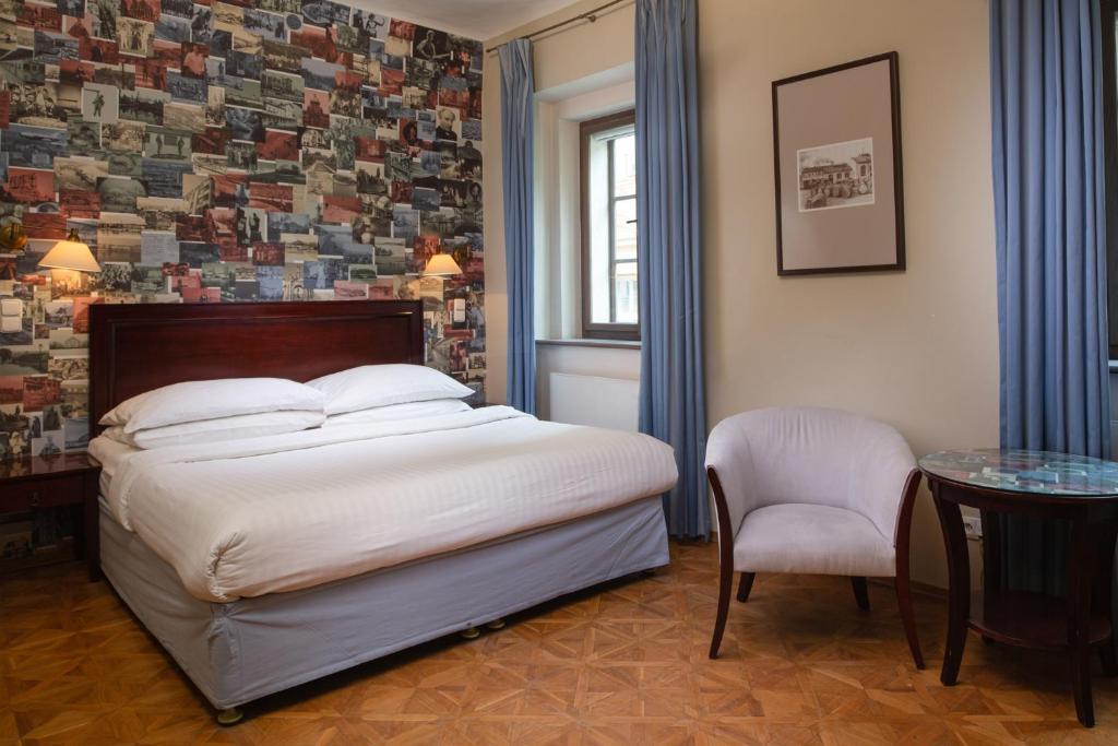 布拉格Charles Bridge Rooms & Suites by SIVEK HOTELS的卧室配有1张床、1张桌子和1把椅子