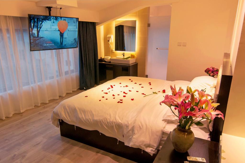 大理大理古城素色精品客栈的一间卧室配有一张带花瓣的床。