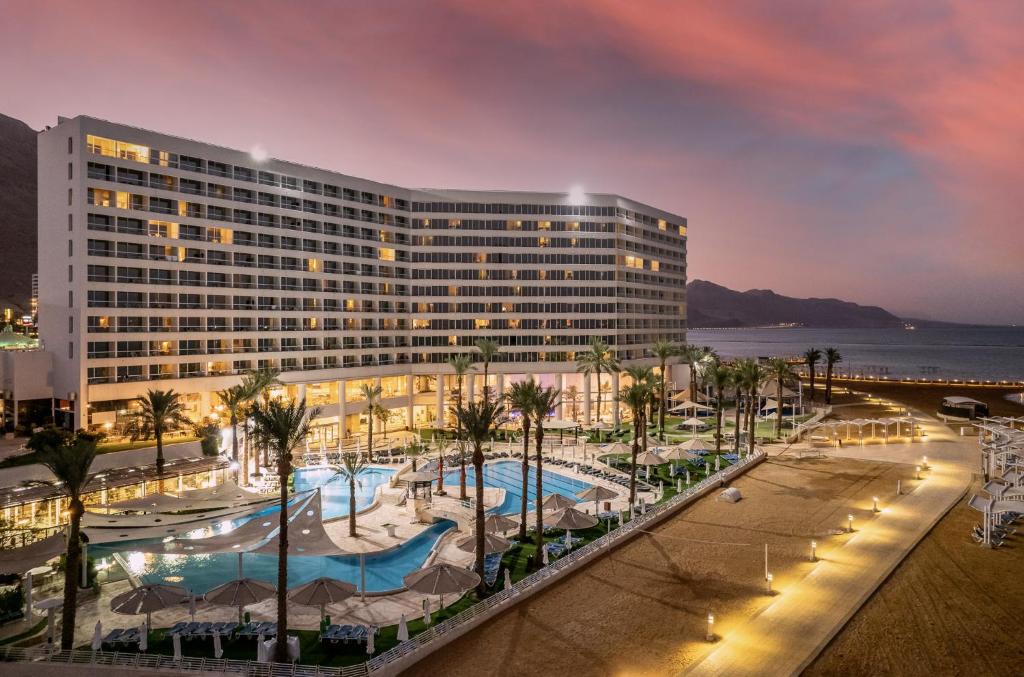 恩波其克Vert Dead Sea by AFI Hotels的一座建筑前拥有游泳池和棕榈树的酒店
