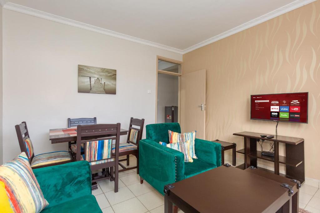 埃尔多雷特Fully furnished 1-bedroom Apartment in Eldoret的客厅配有绿色椅子和电视