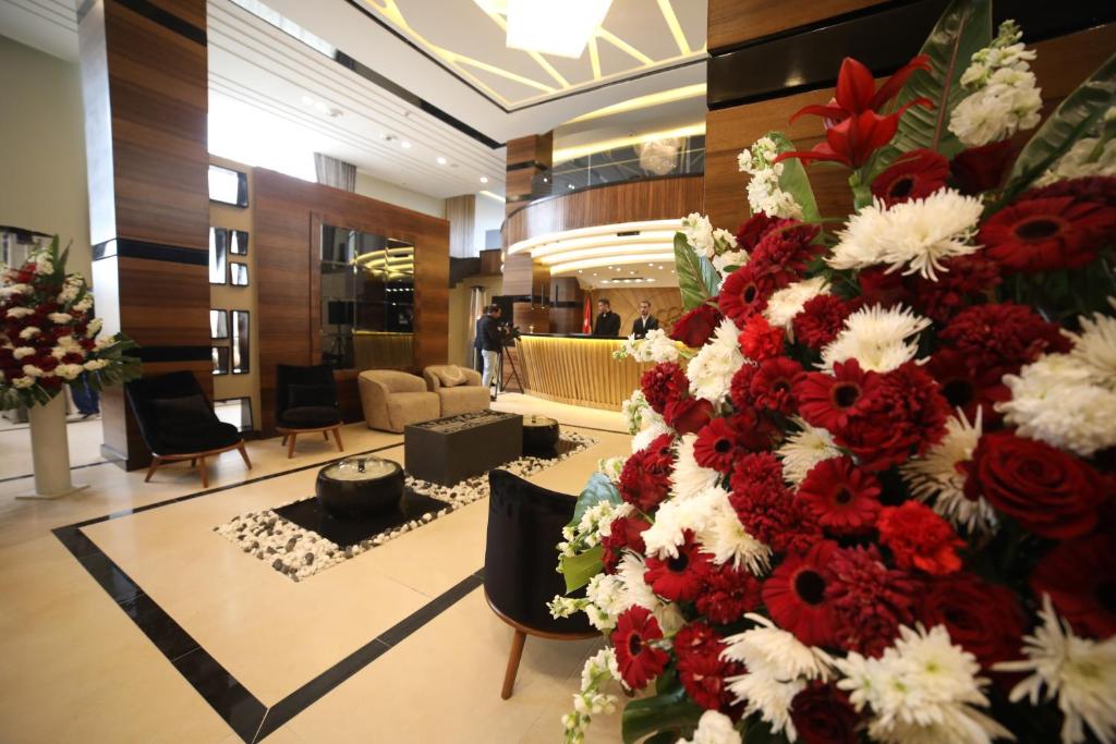 安曼فندق صحارى الخليج Sahara Gulf Hotel Apartments的大堂里一大堆红白花