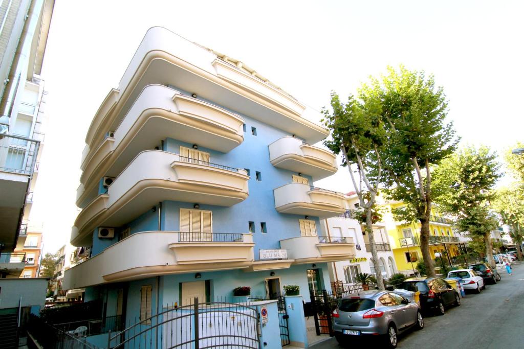 里米尼Residence Blu Marine的城市街道上带阳台的蓝色建筑