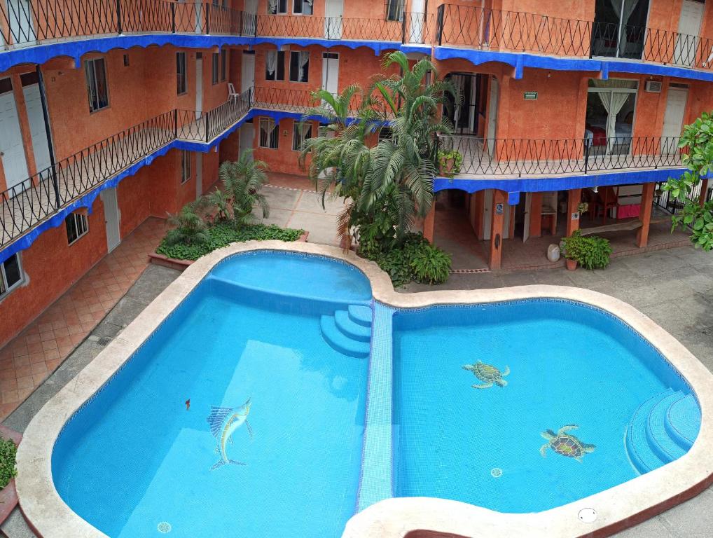 洛斯阿亚拉Hotel Y Bungalows Islas Careyes的大楼前方大型蓝色游泳池的顶部景色