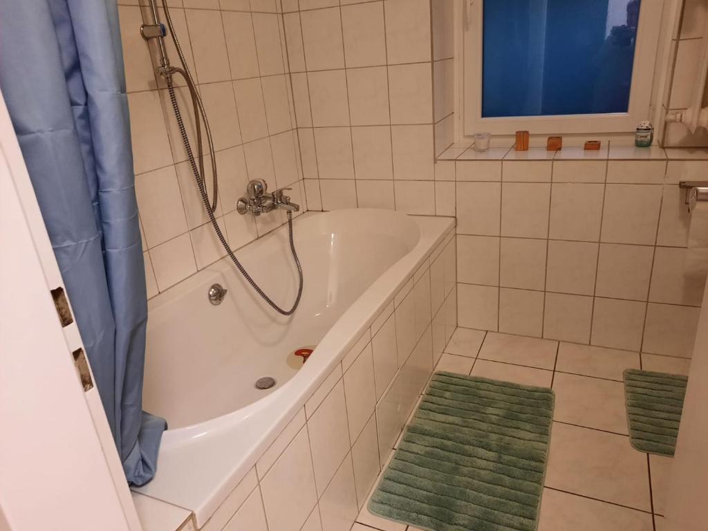 茨魏布肯Ferienwohnung Elena的带浴缸和绿色地毯的浴室