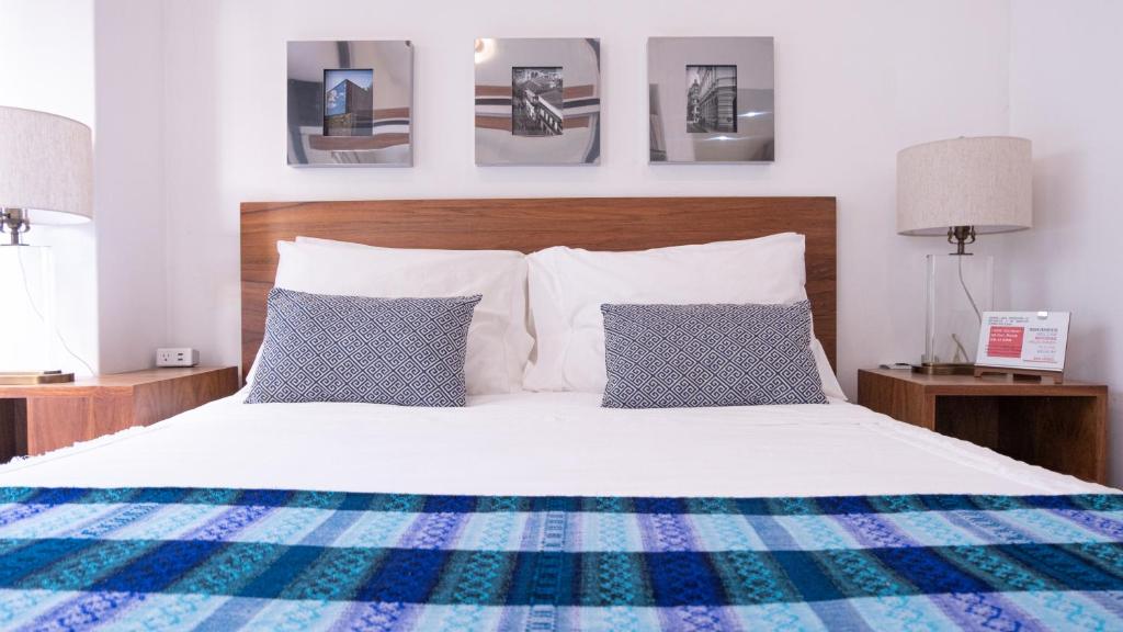 墨西哥城Habitación Privada para disfrutar en la Ciudad de México的卧室配有白色床和蓝色及白色枕头