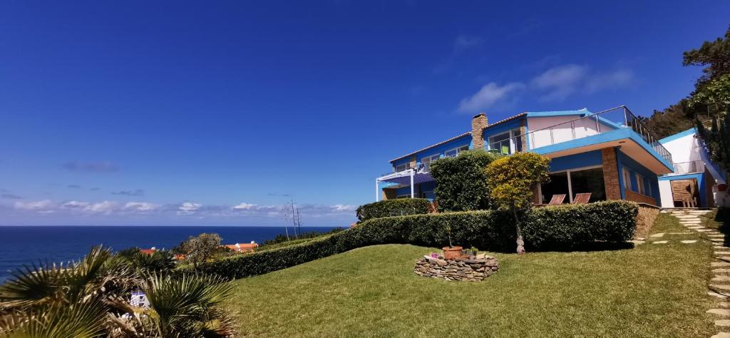 辛特拉Mega Ocean Magoito - Guest House - Sintra的一座山丘上的房屋,背景是大海