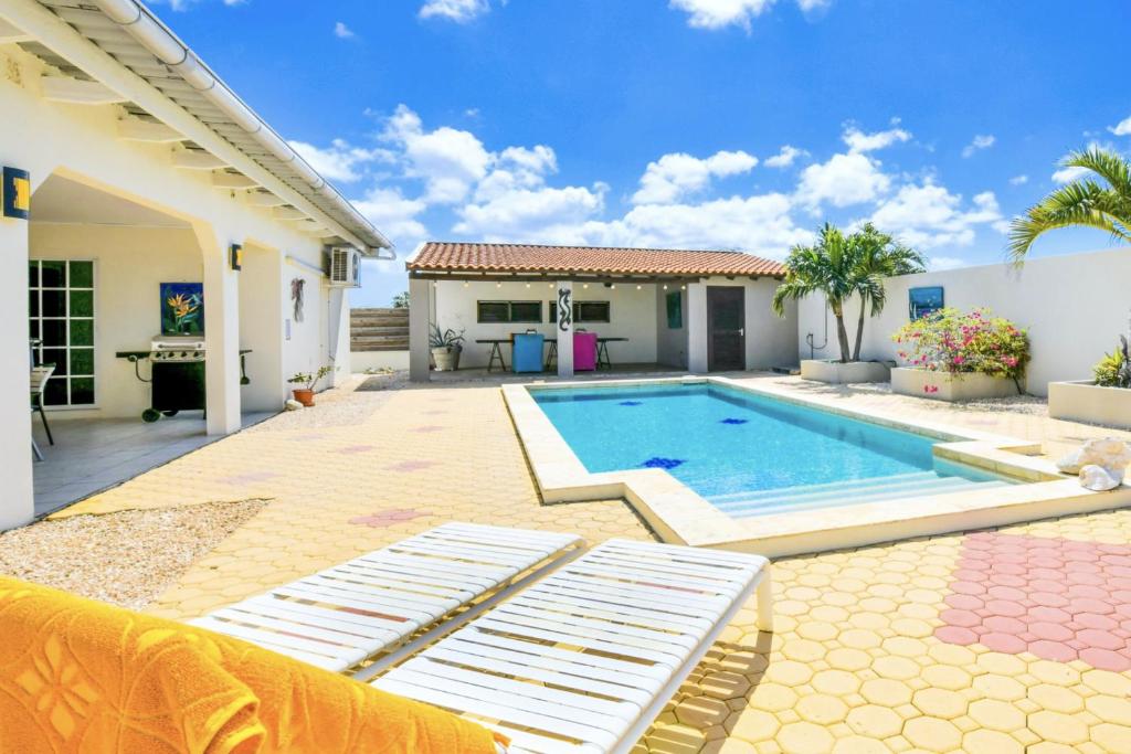 棕榈滩Sunny Palm Beach Villa的一个带游泳池和房子的后院
