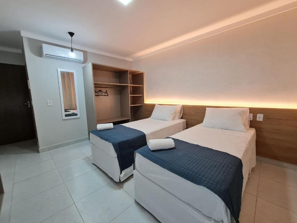 巴纳伊巴Hotel Aveiro的一间酒店客房,房间内设有两张床