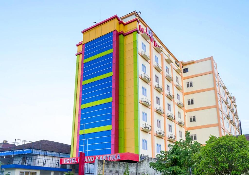 沙马林达Hotel Grand Kartika的色彩鲜艳的建筑,上面有标志