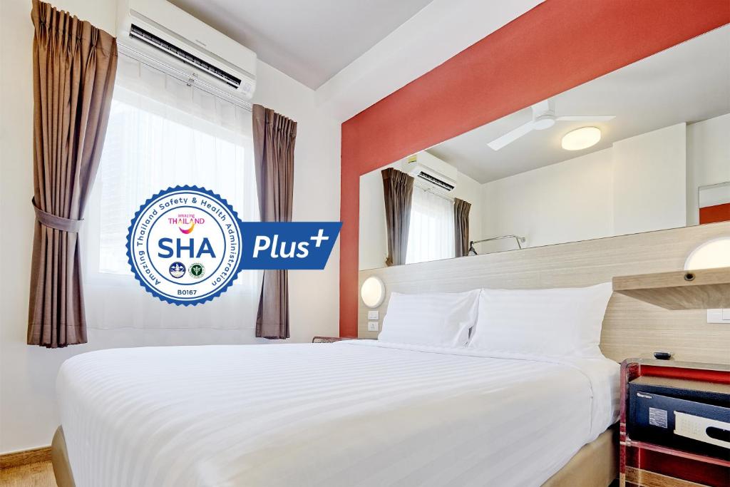 芭东海滩Red Planet Phuket Patong - SHA Extra Plus的一间卧室配有一张带丝绸标志的床,