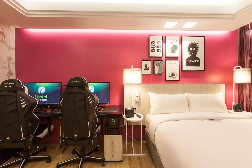 中坜i hotel 中壢館的一间卧室配有一张床、两张桌子和两个显示器