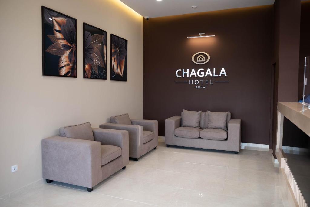 AksayChagala Hotel Aksai的一间配有沙发的等候室和墙上的标志