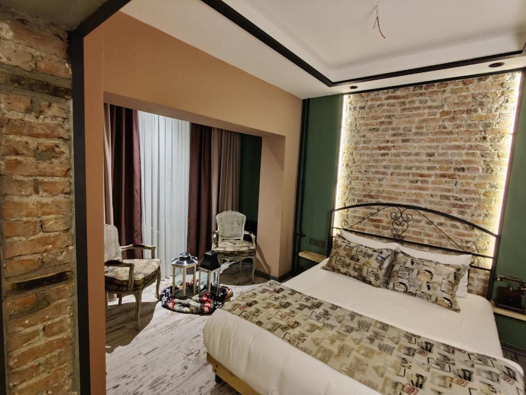 安卡拉ANKA RESİDENCE的一间卧室设有一张床和砖墙