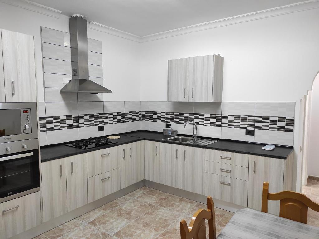 玛泽甘Apartamento para familias的厨房配有白色橱柜和黑色台面