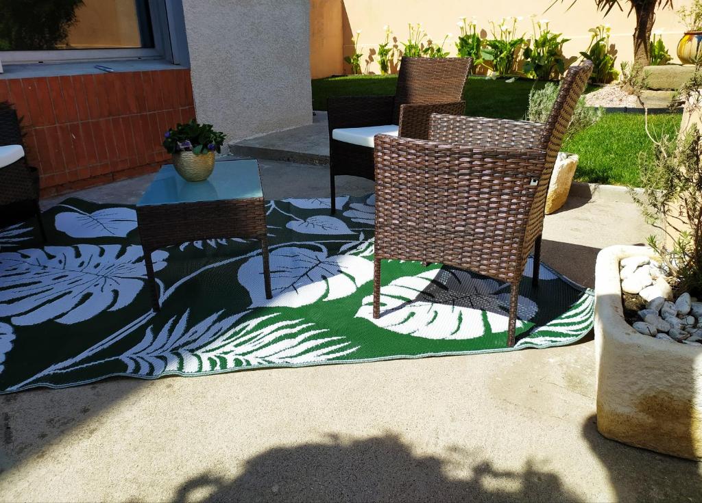 卡尔卡松RIBA D'AUDE的地毯上设有带三把椅子和一张桌子的庭院