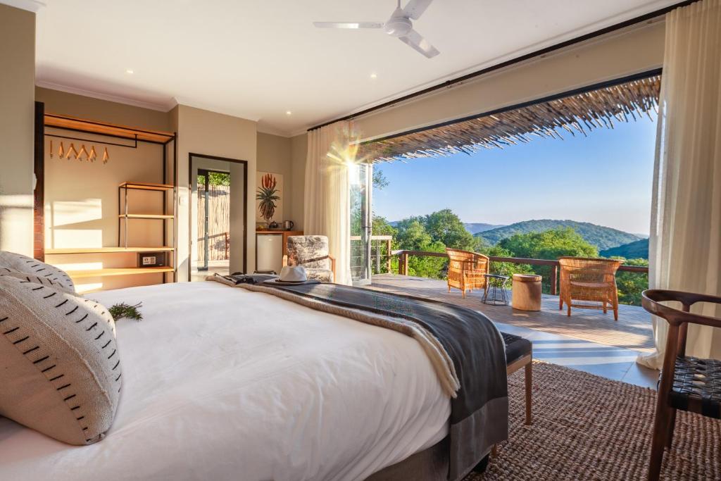 赫卢赫卢韦Sungulwane Private Game Lodge的一间卧室设有一张大床和一个大窗户