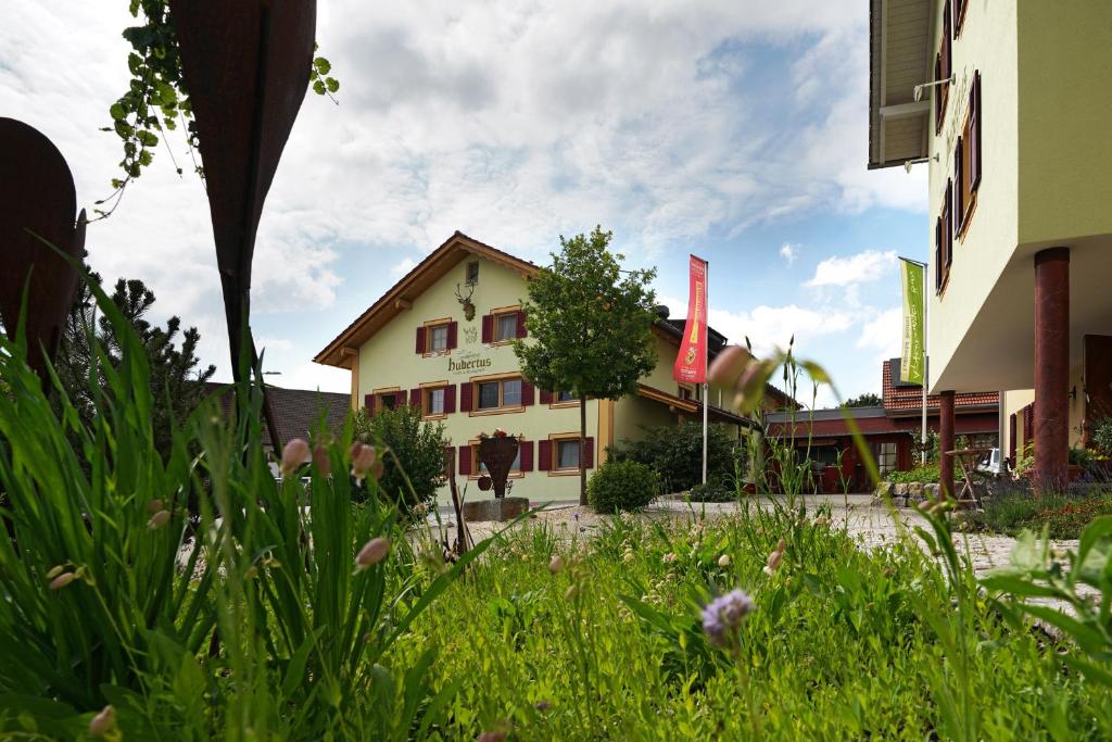 ApfeltrangLandgasthof Hubertus - Braugasthof und Wellnesshotel im Allgäu的草场中间的建筑物