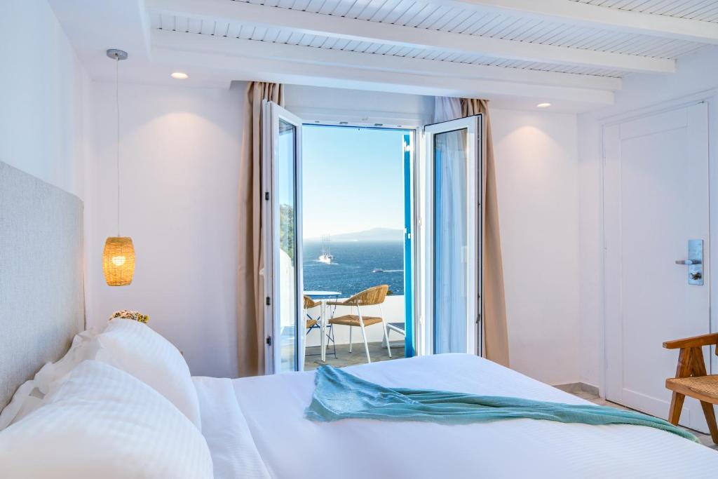 米克诺斯城Hotel Madalena的一间卧室配有一张床,享有海景