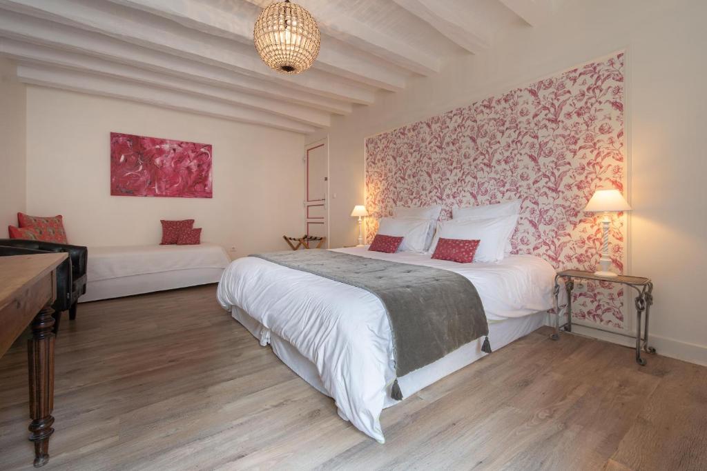 FrancueilLe Clos de La Rousselière B and B的卧室配有一张白色大床和一堵墙