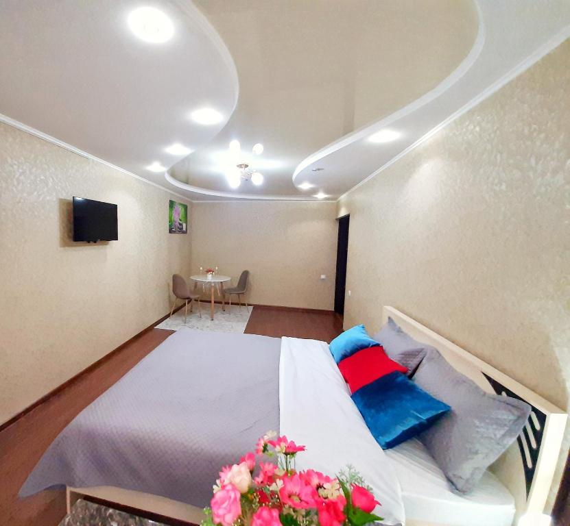 塔拉兹Уютная квартира класса ЛЮКС в городе Тараз的一间卧室配有蓝色和红色枕头的床