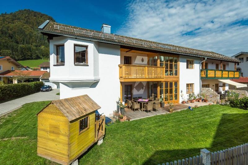 鲁波尔丁Ferienhaus Am Steinbach的院子里有一间白色的大房子,有一间黄色的狗屋
