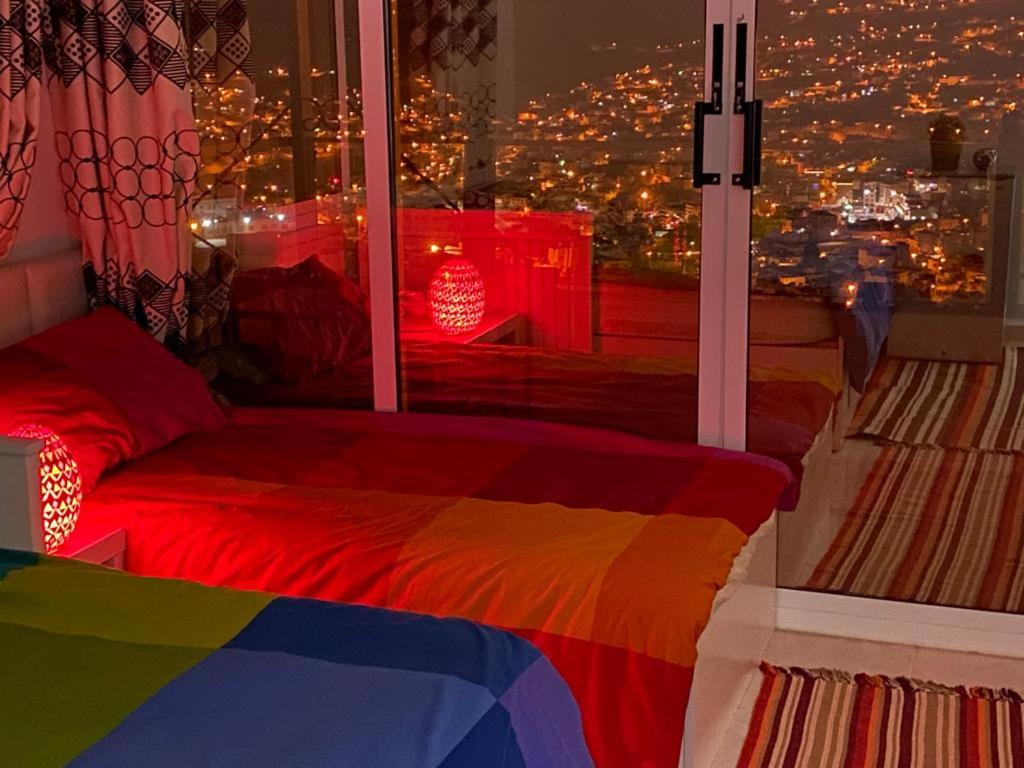 瓦迪穆萨Jordan Guest House的一间卧室设有一张色彩缤纷的床和一个美景窗户。