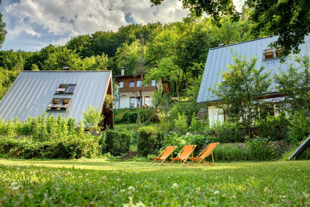 科尼茨Herzegovina Lodges Boracko Jezero的坐在房子前面草坪上的一组椅子