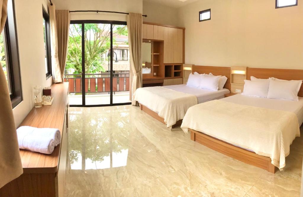 茂物Vimala Hills Villa 4 Bedroom with Mountain View的酒店客房设有两张床和一个阳台。