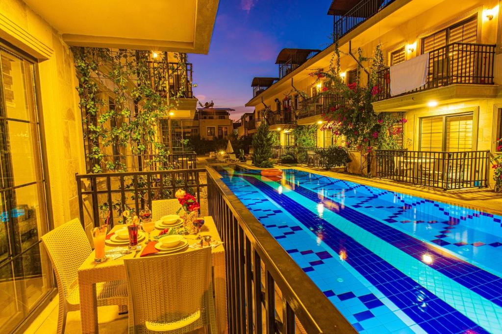 费特希耶Yaşam Park Residence - Fethiye Calis Beach的酒店游泳池旁设有桌椅