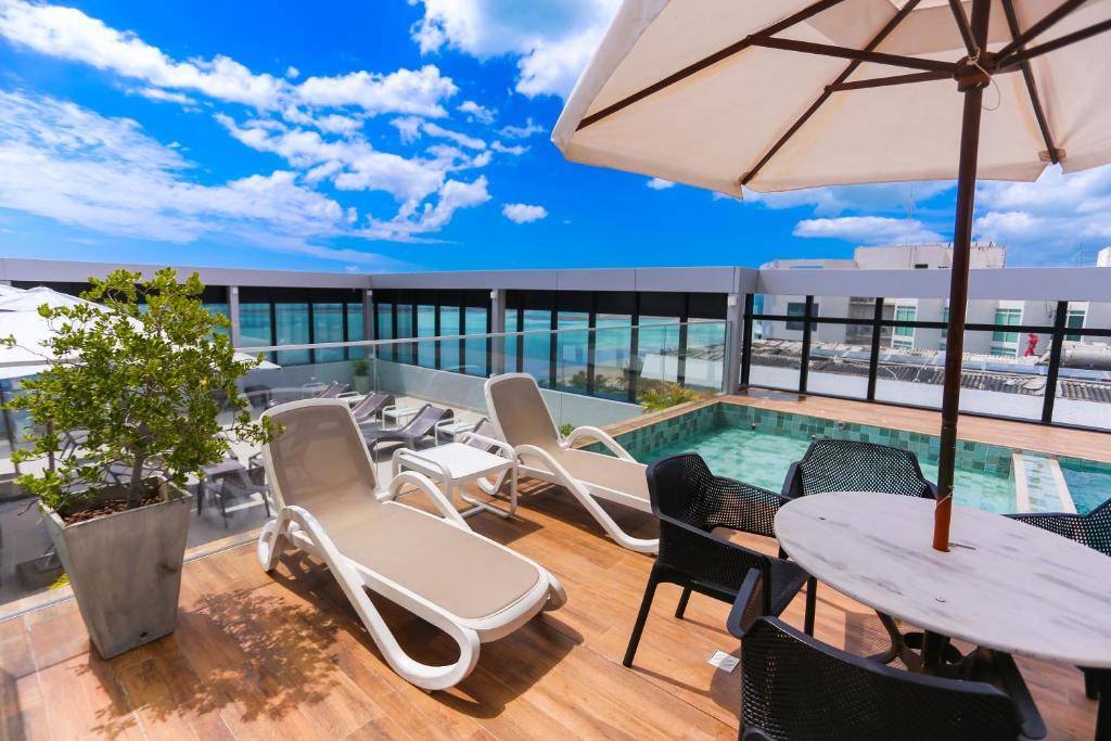 马塞约Pajuçara Praia Hotel的一座带桌椅的庭院和一座位于大楼内的游泳池