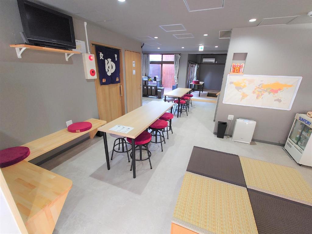 京都酷图斯戴旅馆的一个带桌椅和大屏幕的教室