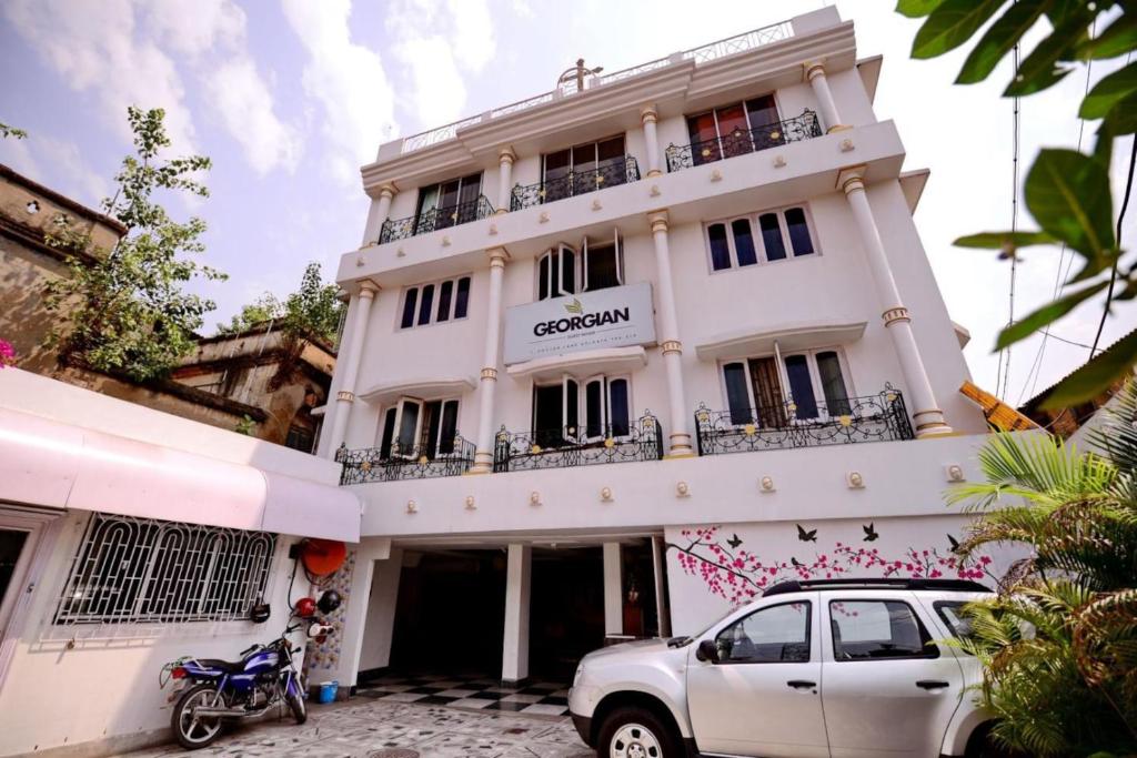 加尔各答格鲁吉亚酒店的前面有一辆汽车停放的白色建筑