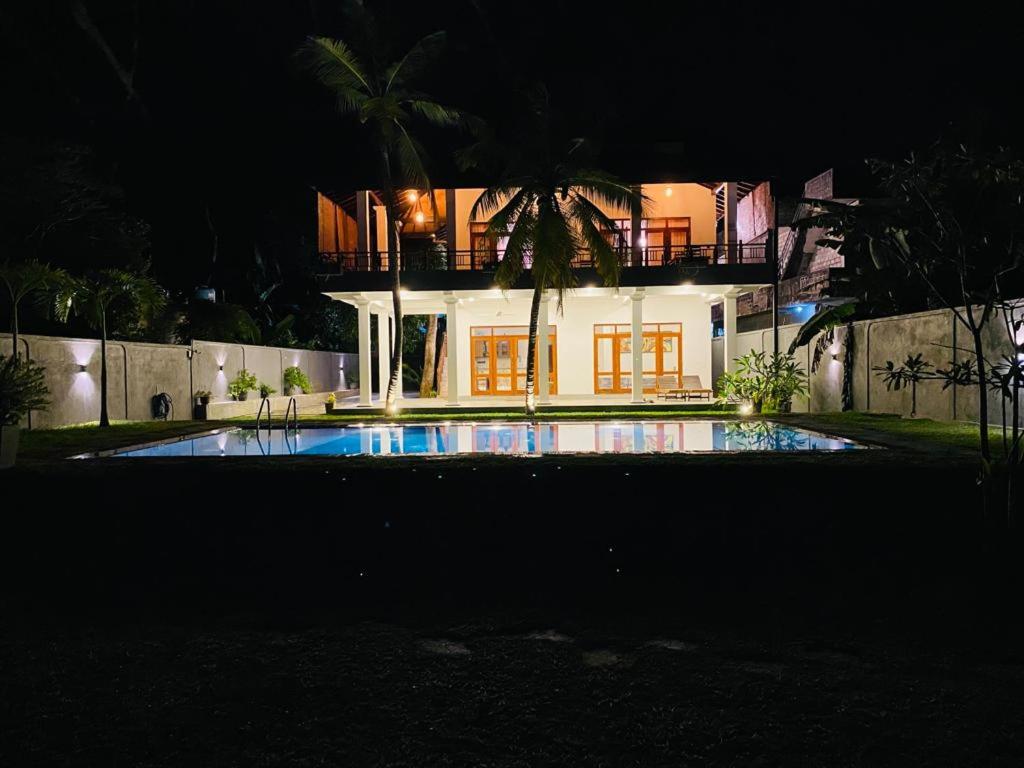本托塔Villa Maria的一座在晚上设有游泳池的大房子