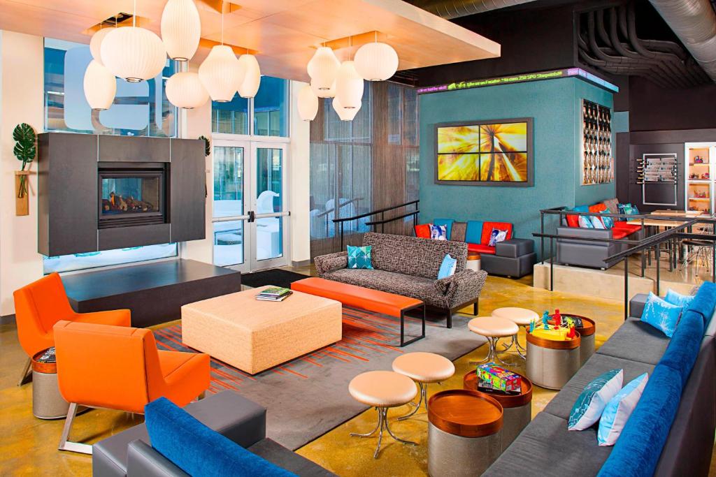 比奇伍德比奇伍德雅乐轩酒店的客厅配有蓝色和橙色家具和壁炉