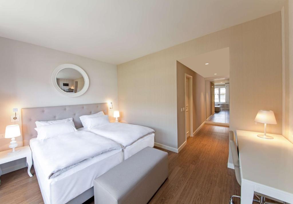 日内瓦Geneva By Fassbind的白色卧室配有一张大床和一张桌子