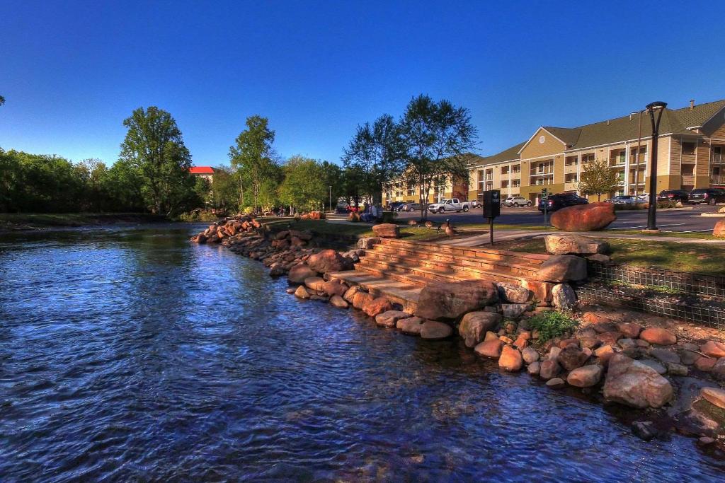 鸽子谷Econo Lodge Pigeon Forge Riverside的一条河,街道边有岩石