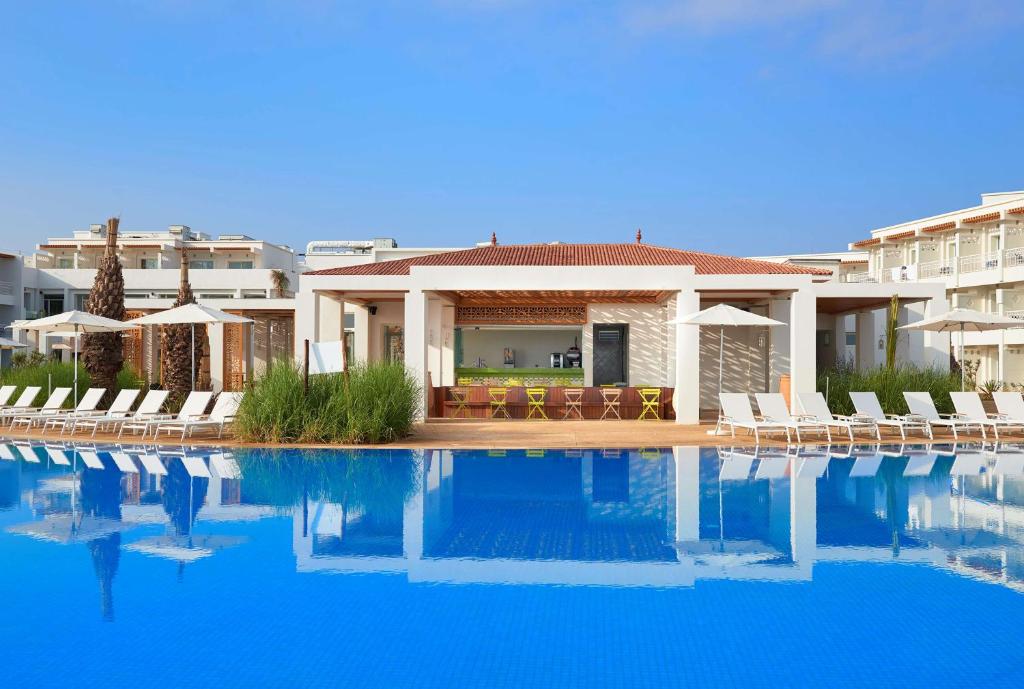 萨伊迪耶Radisson Blu Resort Saidia Beach的一座别墅,在一座建筑前设有一个游泳池