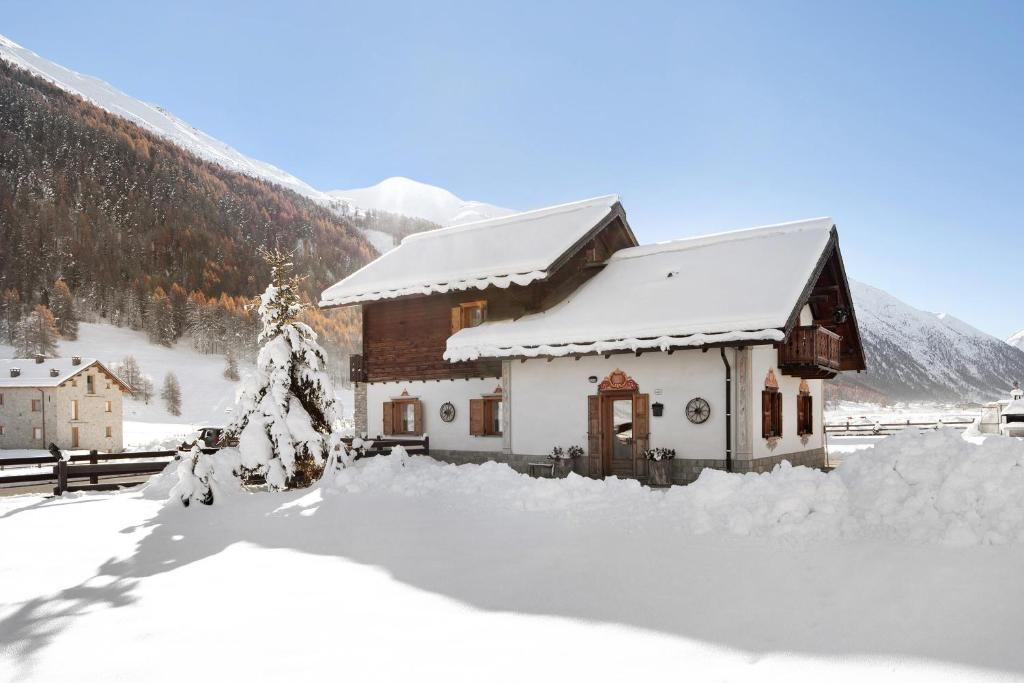 利维尼奥Baita sulle Alpi的山前雪覆盖的房子