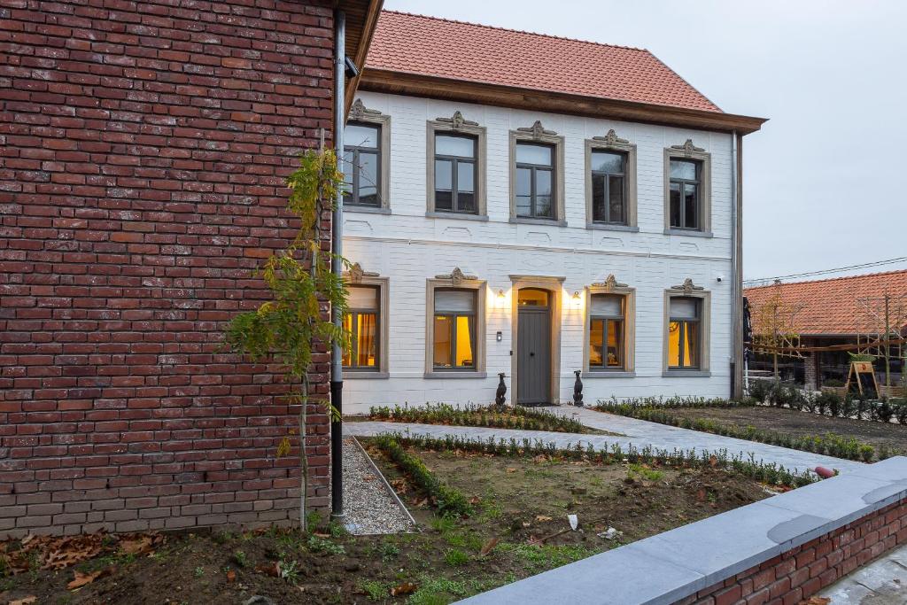 Etikhove't Verschil的白色的房子,有黄色的门和砖砌建筑