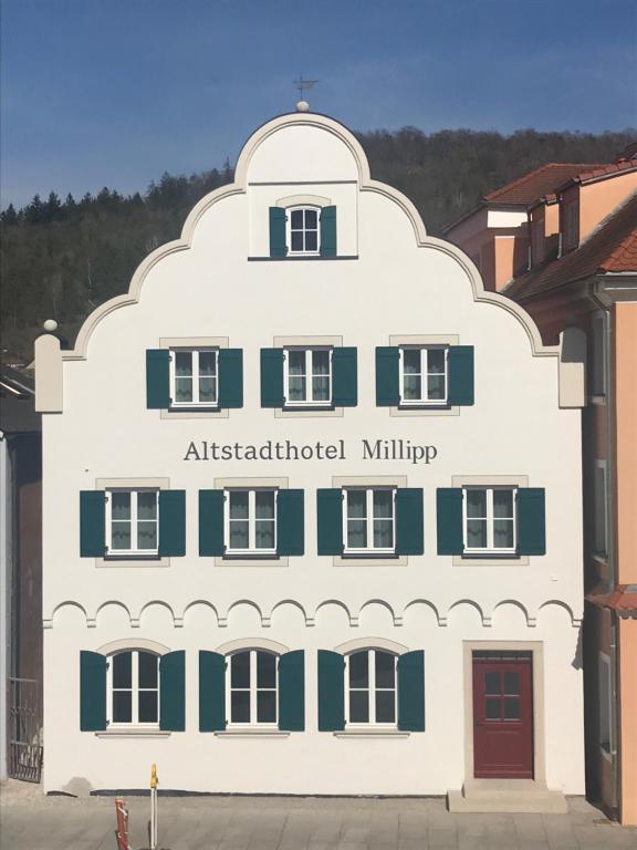 拜尔恩格里斯Altstadthotel Millipp的一座白色的大建筑,有澳大利亚文化部的字眼