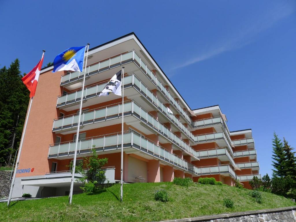 阿罗萨Apartment Promenade - Utoring-74 by Interhome的前面有旗帜的建筑