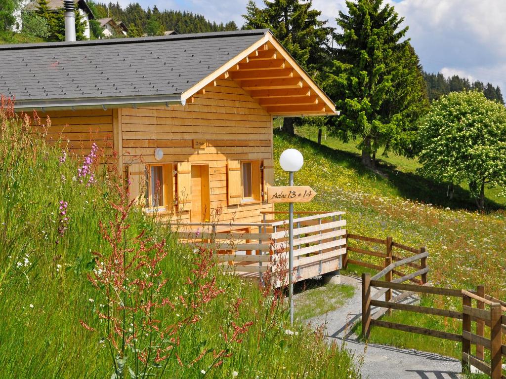 UrmeinHoliday Home Komfort Aclas Maiensäss Resort-1 by Interhome的一个带围栏的田野上的小木屋