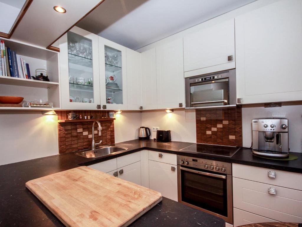 因斯布鲁克Apartment Tivoli by Interhome的厨房配有白色橱柜和木制切板